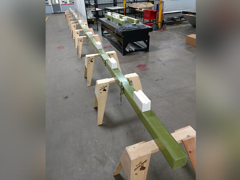 Fiberglass modular antenna support test structure deployed in a warehouse while supported by a row of sawhorses.